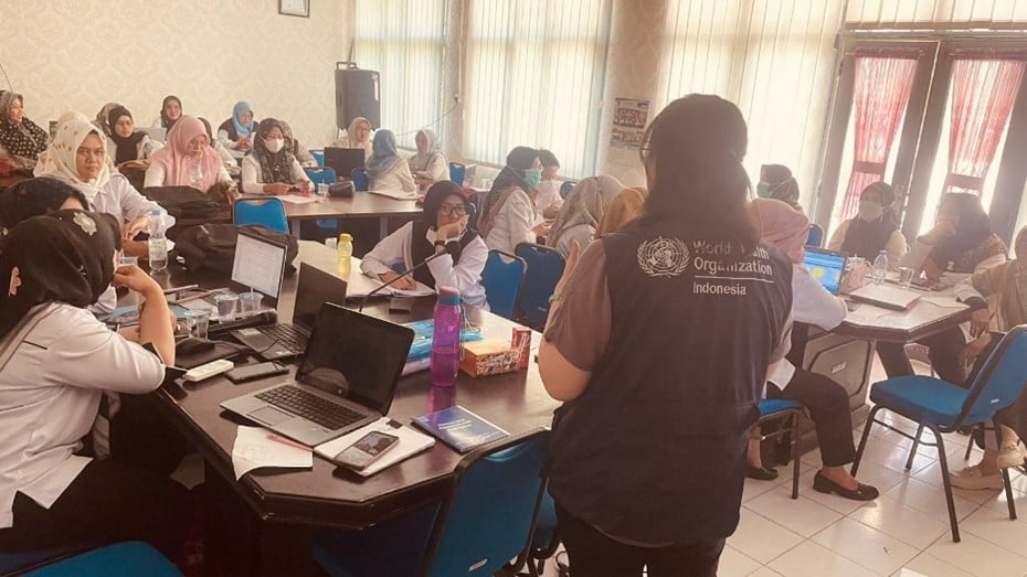 WHO Vaccination Technical Officer in front of a class of health care workers